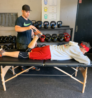 IMG_0381 Personal trainer performing mobility assessment on client.